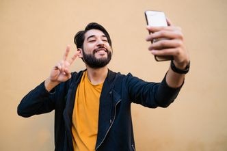 Portrait of attractive young man taking selfies with his mophile phone